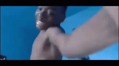 A Man Is Being Punched In The Face In A Pool . GIF