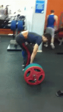 A Man Is Bending Over To Pick Up A Colorful Barbell GIF