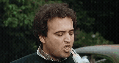A Man Is Blowing A Kiss At A Bird While Standing In Front Of A Car . GIF