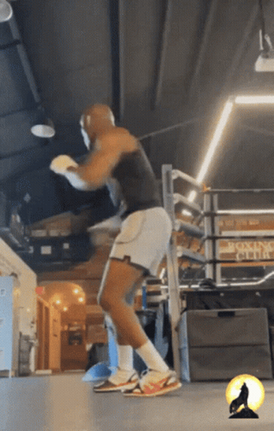 A Man Is Boxing In A Gym With A Sign That Says Boxing Club GIF