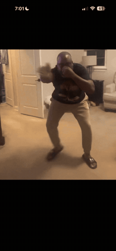 A Man Is Boxing In A Living Room With The Time 7:01 GIF