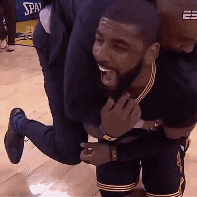 A Man Is Carrying A Basketball Player On His Back On A Wooden Floor . GIF
