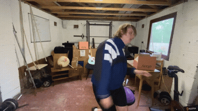 A Man Is Carrying A Box That Says Aeocd On It GIF