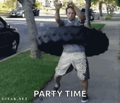 A Man Is Carrying A Large Black Bag On His Shoulders While Standing On A Sidewalk . GIF
