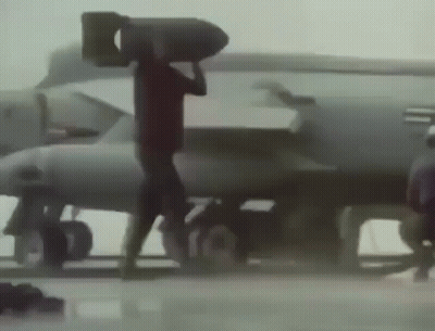 A Man Is Carrying A Large Bomb On His Head GIF