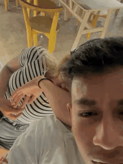 A Man Is Carrying A Woman On His Shoulders In A Room . GIF