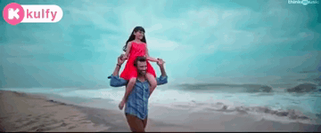 A Man Is Carrying A Woman On His Shoulders On The Beach GIF