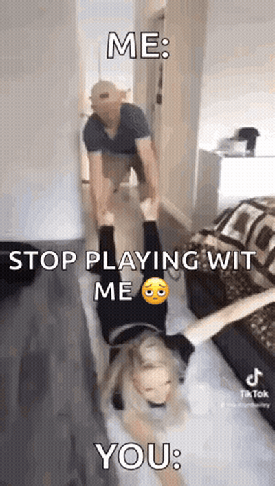 A Man Is Carrying A Woman Upside Down On His Shoulders In A Room . GIF