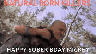 A Man Is Carrying Another Man In His Arms With The Words " Happy Sober Bday Mickey " On The Bottom GIF