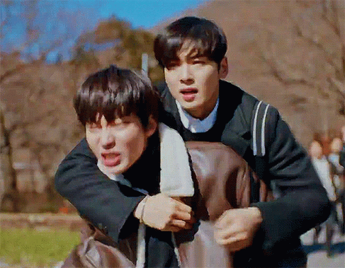 A Man Is Carrying Another Man On His Back And They Are Making Funny Faces . GIF