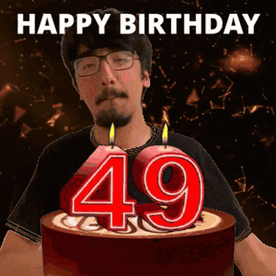 A Man Is Celebrating His 49Th Birthday With A Cake With Candles In The Shape Of The Number 49 GIF