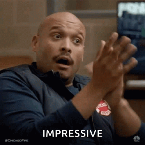 A Man Is Clapping His Hands And Making A Surprised Face While Sitting In Front Of A Television . GIF