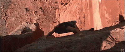 A Man Is Climbing Up A Rocky Cliff With The Number 70 In The Corner . GIF