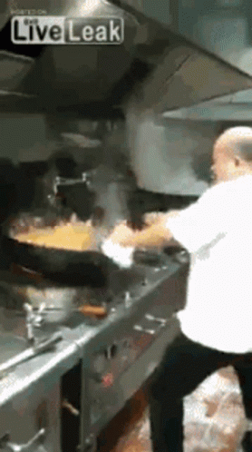 A Man Is Cooking Food In A Kitchen With A Live Leak Watermark GIF