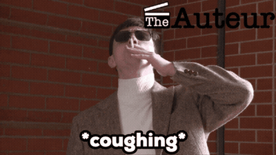 A Man Is Coughing In Front Of A Brick Wall With The Authors Logo GIF