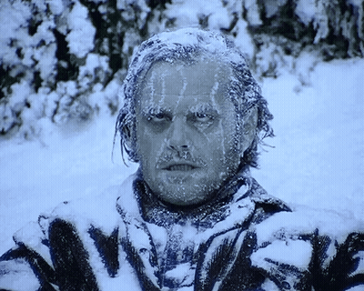 A Man Is Covered In Snow And Ice And Has The Word Nightmare On His Shirt GIF