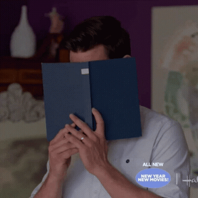 A Man Is Covering His Face With A Book And The Words All New New Year New Movies Are Below Him GIF