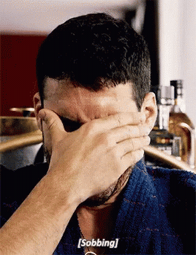 A Man Is Covering His Face With His Hand And Saying Sobbing GIF