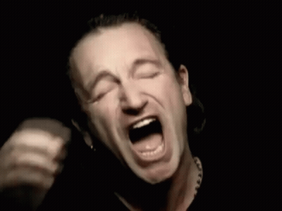 A Man Is Covering His Face With His Hands While Screaming In The Dark . GIF