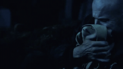 A Man Is Covering His Mouth With A Napkin In The Dark . GIF