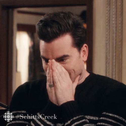 A Man Is Covering His Mouth With His Hands And The Word Schitts Creek Is On The Bottom Right GIF