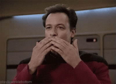 A Man Is Covering His Mouth With His Hands While Wearing A Red Shirt . GIF