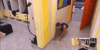 A Man Is Crawling On The Floor In A Room With Yellow And Blue Walls . GIF