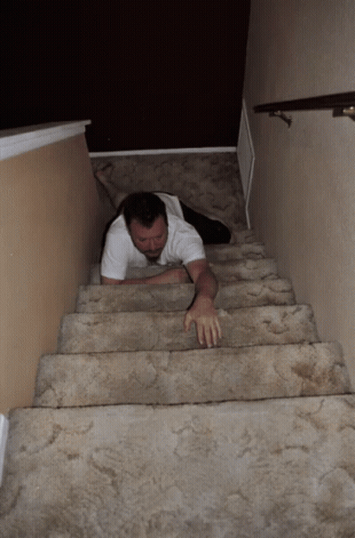 A Man Is Crawling Up A Set Of Stairs With His Legs Crossed GIF
