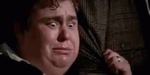 A Man Is Crying And Talking On A Cell Phone . GIF