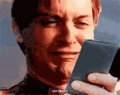 A Man Is Crying While Holding A Cell Phone . GIF