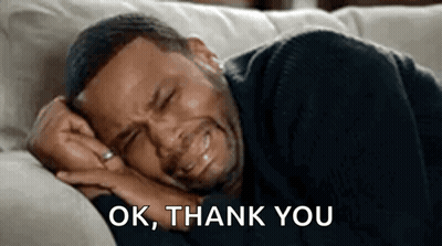 A Man Is Crying While Laying On A Couch . GIF