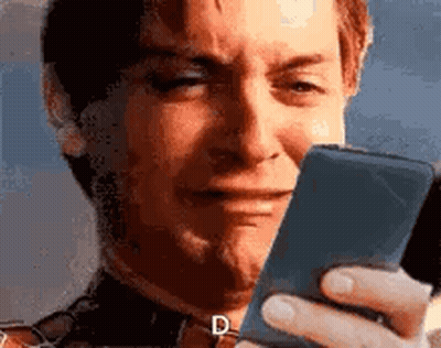 A Man Is Crying While Looking At His Phone . GIF