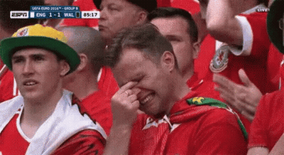 A Man Is Crying While Watching A Soccer Game In A Crowd . GIF