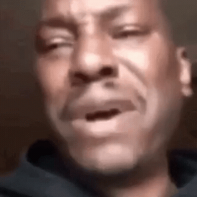 A Man Is Crying With His Eyes Closed And His Mouth Open . GIF
