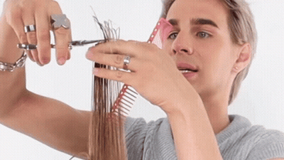 A Man Is Cutting His Hair With A Pair Of Scissors And A Comb GIF