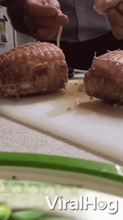 A Man Is Cutting Meat On A Cutting Board With The Words Viralhog Written On The Bottom GIF