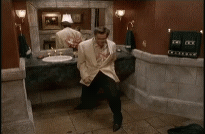 A Man Is Dancing In A Bathroom In Front Of A Sink . GIF