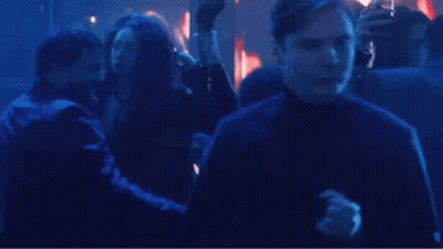 A Man Is Dancing In A Crowd Of People At A Party In A Club . GIF