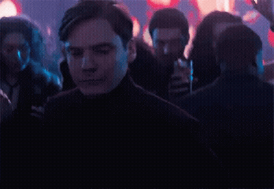 A Man Is Dancing In A Crowd Of People At A Party In A Dark Room . GIF