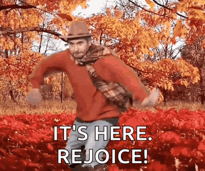 A Man Is Dancing In A Field Of Red Leaves With The Words `` It 'S Here Rejoice '' . GIF