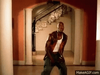 A Man Is Dancing In A Hallway Next To Stairs . GIF