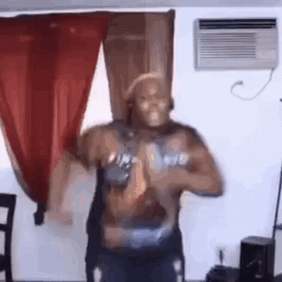 A Man Is Dancing In A Living Room In Front Of A Window And Air Conditioner . GIF