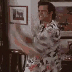 A Man Is Dancing In A Living Room While Holding A Guitar . GIF