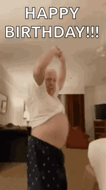 A Man Is Dancing In A Living Room While Wearing Pajamas And A White Shirt . GIF