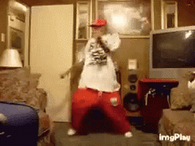 A Man Is Dancing In A Living Room With A Microphone In His Hand GIF