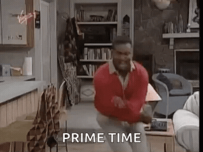 A Man Is Dancing In A Living Room With The Words `` Prime Time '' Written Above Him . GIF