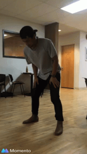 A Man Is Dancing In A Room With A Momento Icon In The Corner GIF