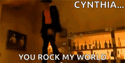 A Man Is Dancing In A Room With The Words Cynthia You Rock My World Written Above Him GIF