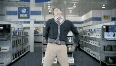 A Man Is Dancing In A Store With A Sign That Says Best Buy In The Background GIF