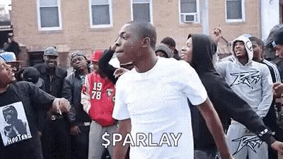 A Man Is Dancing In Front Of A Crowd Of People . GIF
